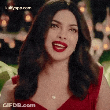 The Woman Is Wearing A Red Dress And Red Lipstick And Smiling . GIF