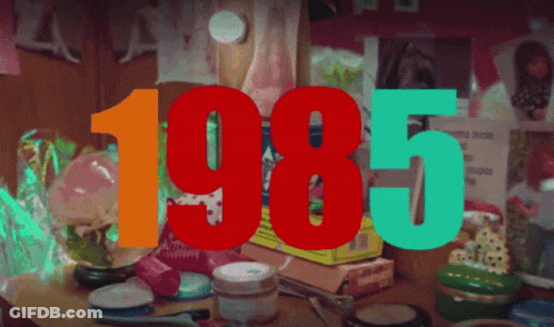 The Year 1985 Is Displayed On A Table Full Of Cosmetics GIF