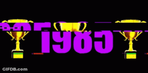 The Year 1985 Is Displayed With Two Trophies In The Background GIF