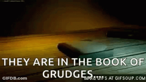 They Are In The Book Of Grudge Written On A Wooden Surface . GIF