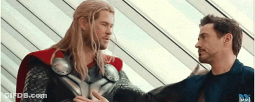 Thor And Iron Man Are Standing Next To Each Other In A Room . GIF