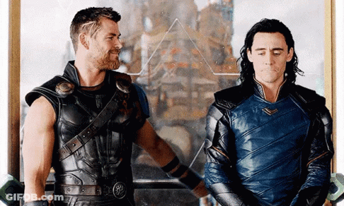 Thor And Loki Are Standing Next To Each Other In Front Of A Mirror In A Room . GIF