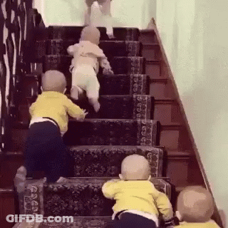 Three Babies Are Climbing Up A Set Of Stairs Together . GIF