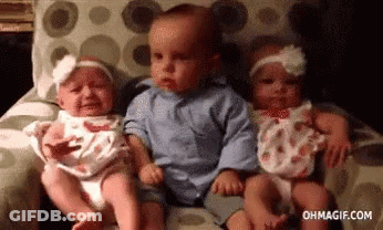 Three Babies Are Sitting Next To Each Other On A Couch And One Of Them Is Crying . GIF