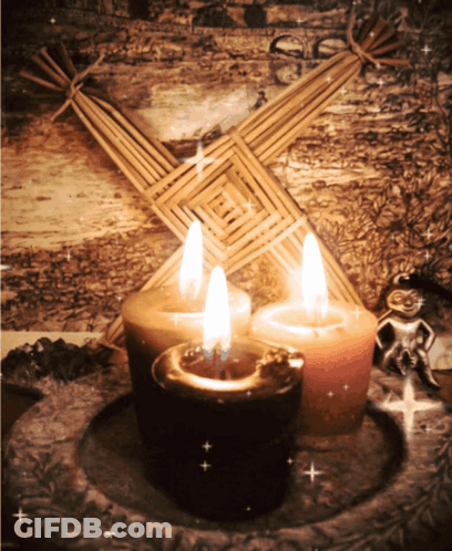 Three Candles In Front Of Straw Cross GIF