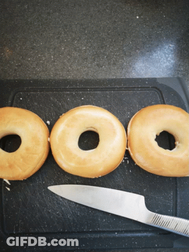 Three Donuts On Cutting Board With Knife GIF