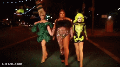Three Drag Queens Walking At Night Holding Hands GIF