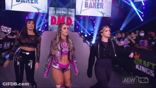 Three Female Wrestlers Are Walking Down The Aisle At A Wrestling Show GIF
