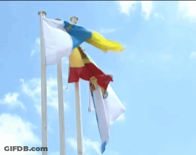 Three Flags Are Flying In The Wind Against A Blue Sky With Clouds GIF