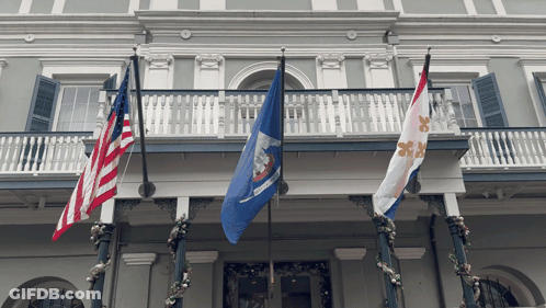 Three Flags On A Balcony Including One That Says Louisiana On It GIF