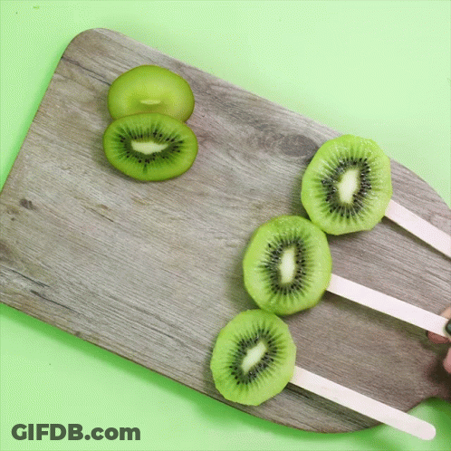 Three Kiwi Popsicle Slices On Wooden Board GIF