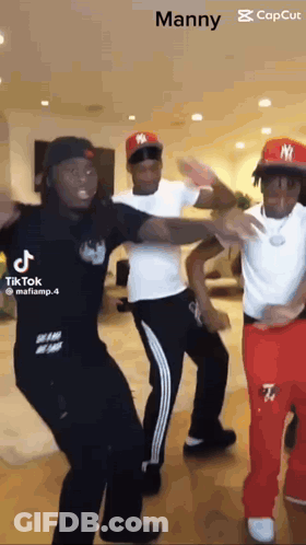 Three Men Are Dancing Together In A Room . GIF
