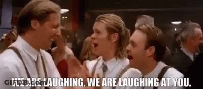 Three Men Are Laughing At Each Other In A Crowded Room . GIF