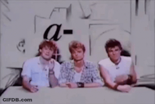 Three Men Are Sitting At A Table And Talking To Each Other . GIF