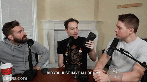 Three Men Are Sitting At A Table With Microphones And One Of Them Is Wearing A Shirt That Says Ipa Hints GIF