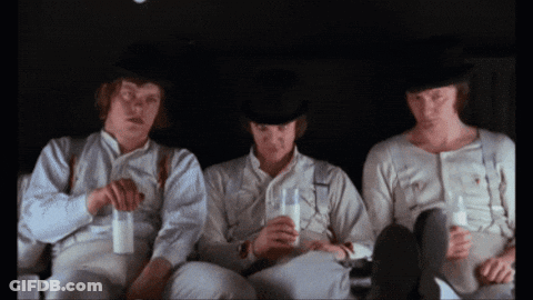 Three Men Are Sitting In A Dark Room Drinking Milk From Glasses GIF