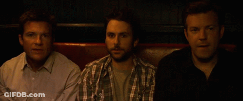 Three Men Are Sitting Next To Each Other On A Couch GIF