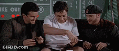 Three Men Are Sitting On A Couch In Front Of A Scoreboard And Laughing . GIF