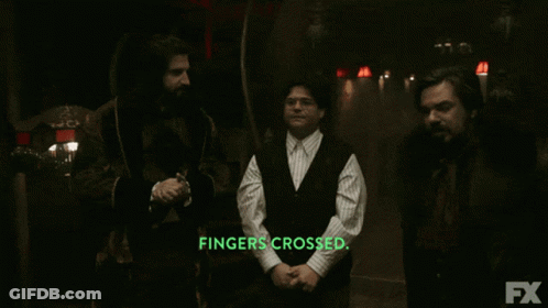 Three Men Are Standing In A Dark Room With The Words Fingers Crossed In Green Letters GIF
