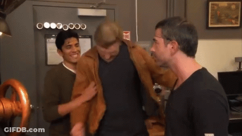 Three Men Are Standing In Front Of A Door That Has A Fire Extinguisher Sign On It GIF