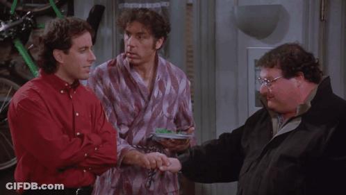 Three Men Are Standing Next To Each Other And One Of Them Is Holding A Remote Control GIF