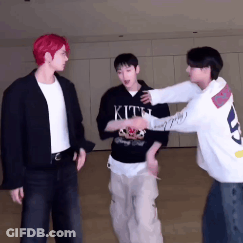Three Men Are Standing Next To Each Other In A Room . GIF