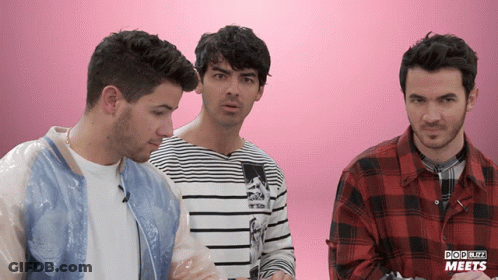 Three Men Are Standing Next To Each Other In Front Of A Pink Background That Says Pop Blitz Meets On It GIF