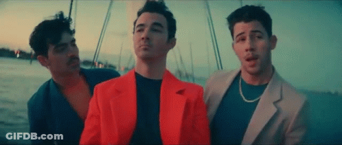 Three Men Are Standing Next To Each Other On A Boat In The Ocean . GIF