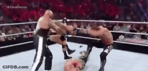 Three Men Are Wrestling In A Ring With A Referee . GIF