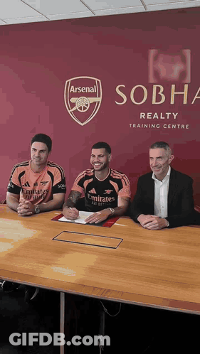 Three Men At Table In Front Of Sobha Realty Training Centre Sign GIF
