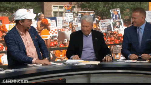 Three Men At Table With Cheerleader And Spike Sign GIF