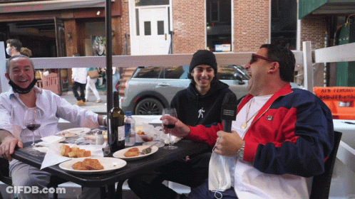 Three Men At Table With Food And Wine GIF