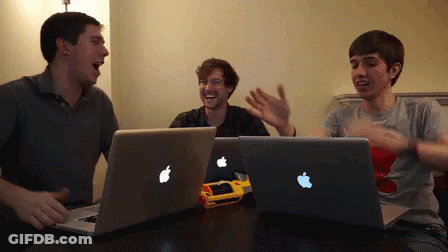 Three Men At Table With Two Apple Laptops GIF