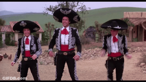 Three Men Dressed In Mariachi Outfits Are Dancing In A Dirt Field GIF