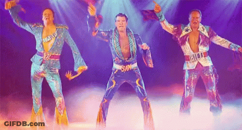 Three Men In Colorful Costumes Are Dancing On A Stage In Front Of A Crowd . GIF