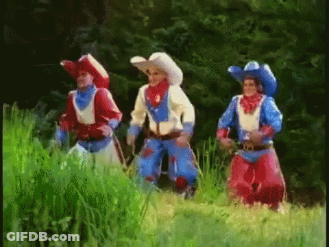 Three Men In Cowboy Costumes Standing In Field GIF