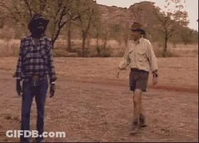 Three Men In Cowboy Hats Are Standing In A Field . GIF