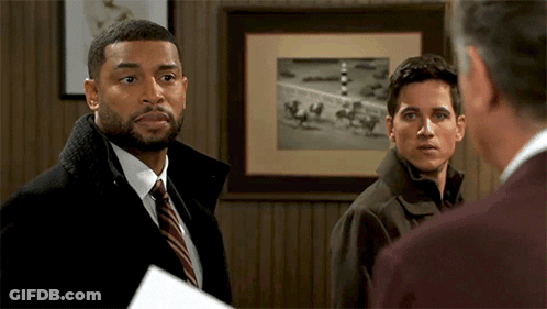 Three Men In Front Of Framed Picture Of Horses On Track GIF