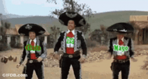 Three Men In Mariachi Costumes Are Dancing In A Desert GIF