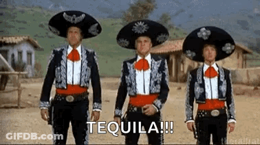 Three Men In Mariachi Costumes Are Standing Next To Each Other In A Row In A Desert . GIF
