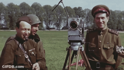 Three Men In Military Uniforms In A Field With Camera GIF