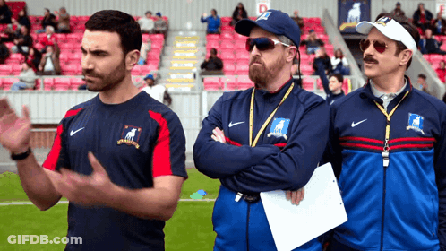 Three Men In Nike Jackets Standing On Field GIF