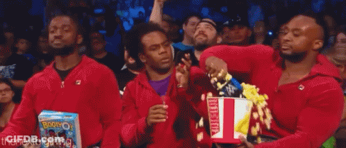 Three Men In Red Jackets Holding Popcorn GIF