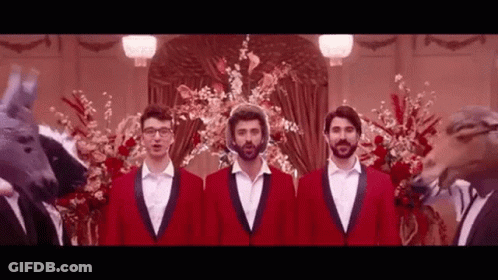 Three Men In Red Suits Are Standing Next To Each Other In Front Of A Fake Horse Head . GIF