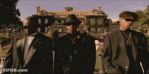 Three Men In Suits And Hats Are Standing In Front Of A Large House GIF