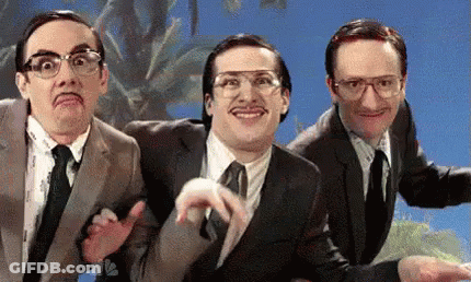 Three Men In Suits And Ties Are Making Funny Faces In Front Of A Blue Sky . GIF