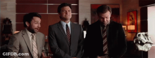 Three Men In Suits And Ties Are Standing Next To Each Other In Front Of A Dinosaur Skeleton . GIF