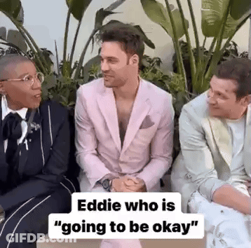 Three Men In Suits Are Sitting Next To Each Other And Talking . One Of The Men Is Wearing A Pink Suit . GIF
