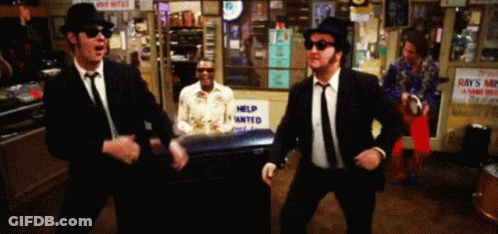 Three Men In Suits Dancing In Front Of Help Wanted Sign GIF