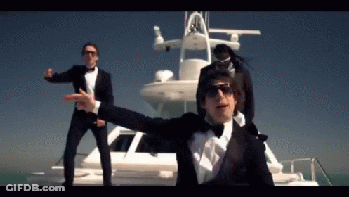 Three Men In Tuxedos Are Standing On A Boat GIF